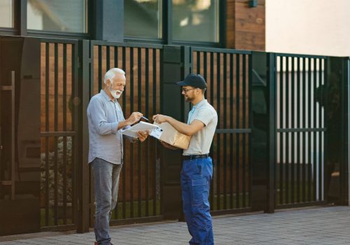 happy-senior-customer-signing-courier-home-delivery-1